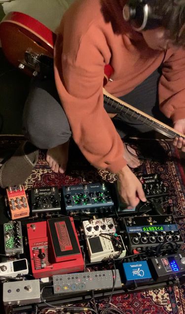 Me sitting in front of a guitar pedalboard